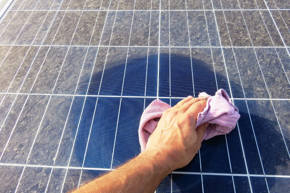 Zonnepanelen schoonmaken met een zachte doek om vuil en vogelpoep te verwijderen voor beter rendement.